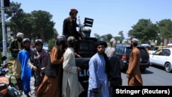 Luptători afgani patrulează pe o stradă din Herat, pe 14 august 2021.