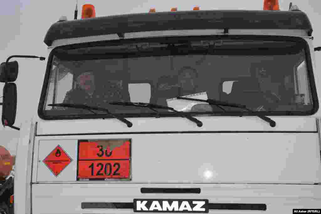 "Ақтөбе мұнай өңдеу" зауыты территориясы алдында тұрған жанармай таситын жүк автокөлігінде отырған адамдар. Ақтөбе, 7 желтоқсан 2016 жыл.