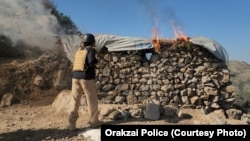 دا انځور د اورکزیو پولیسو د نومبر پر نهمه له رسنیو سره شریک کړی دی چې پکې یو سرتېری ښکاري چې یوه مورچه سوځوي. 