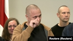 Vital Bandaruk (center) and Larisa Shchyrakova (left) weep as a choir sings a Belarusian folk song at a news conference in Vilnius on September 12, where they and other newly freed prisoners recounted repression and torture behind bars.