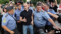 Police officers detain Russian opposition leader Sergei Udaltsov (center) in Moscow on August 9.