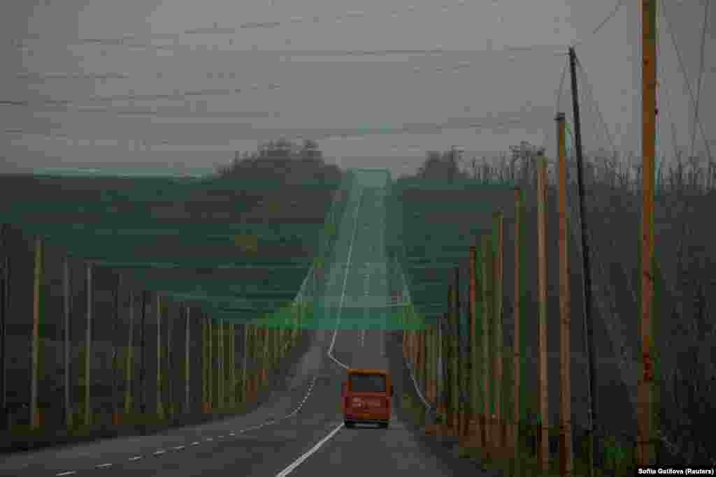 Автомобиль едет по дороге, покрытой антидронной сеткой, недалеко от города Славянск в Донецкой области, Украина, 27 октября 2025 года. REUTERS/Sofiia Gatilova