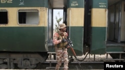سرباز پاکستان در کنار قطار ربوده شده توسط شورشیان در بولچستان - مارچ ۲۰۲۵