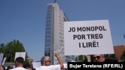 Një protestues mban pankartën me mbishkrimin "Jo monopol por treg i lirë", gjatë një proteste kundër liberalizimit të tregut të energjisë më 11 qershor, Prishtinë.