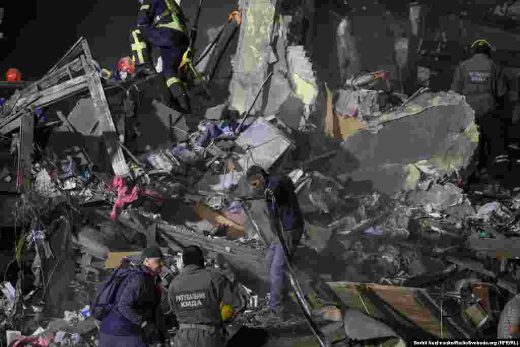 24 aprilie 2025, Kiev, Ucraina – Salvatori la un bloc de apartamente din Kiev, lovit de o rachetă balistică rusească.Echipele de salvare, care au venit să scoată supraviețuitori de sub ruine, au încercat să îi localizeze după sunetul telefoanelor mobile.