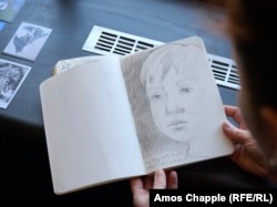 Анна Надуда держит в руках портрет своего сына, который сейчас учится в одной из чешских школ