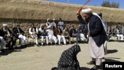 دا د ۲۰۱۵ز کال د اګست ۳۱مې انځور دی چې پکې يو قاضي په غور ولایت کې ښځه په درو وهي.