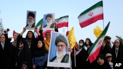Iranian protesters hold their country's flags and posters of Khamenei in an anti-US and anti-Israeli rally in Tehran, June 24