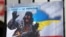 Плакат із зображенням Володимира Путіна у вигляді «зеленого чоловічка» під час акції «Крим – це Україна» біля російського посольства у Києві, 16 березня 2020 року