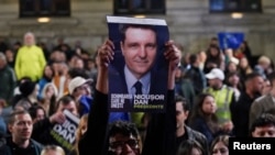 Susținători ai lui Nicușor Dan reacționează după anunțarea sondajelor la ieșirea de la urne, în turul doi al alegerilor prezidențiale din România, București, 19 mai 2025.
