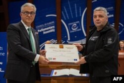 ევროპის საბჭოს საპარლამენტო ასამბლეის პრეზიდენტი თეოდოროს რუსოპულოსი (მარცხენა) და უკრაინელი ჟურნალისტი და ადამიანის უფლებათა დამცველი მაქსიმ ბუტკევიჩი