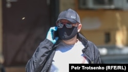 Мужчина в защитной маске идет по улице. Алматы.