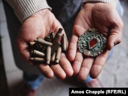 The jeweler holds assorted bullet casings and a finished pendant.