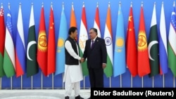 Tajik President Emomali Rahmon (right) shakes hands with Pakistani Prime Minister Imran Khan during the Shanghai Cooperation Organization (SCO) summit in Dushanbe on September 17.