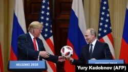 Russian President Vladimir Putin (right) offers a ball from the 2018 soccer World Cup to U.S. President Donald Trump during a joint press conference after a meeting in Helsinki in July 2018.