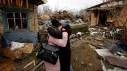 Iana își îmbrățișează o prietenă după ce casa mamei ei, de lângă Kiev, a fost lovită în atacurile rusești cu rachete de joi, 29 decembrie 2022. 