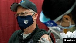 Ministrul american al apărării în exercițiu Christopher Miller primește primul vaccin Pfizer/BioNTech la centrul militar medical din apropiere de Washington, 14 decembrie 2020.