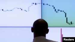An employee looks at an electronic board at RTS stock exchange in Moscow on August 11.