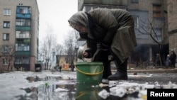 Жінка набирає воду з калюжі у Дебальцеві. Лютий 2015 року 