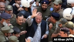 FILE: Police escort jailed former Pakistani prime minister Nawaz Sharif (C) as he leaves the accountability court in Lahore in October 2019.