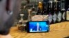 A bartender watches a live stream of Russian President Vladimir Putin's annual televised call-in show in a bar in Moscow on June 30.
