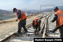 Laborers working on a railway track leading to the Kozmino oil sea terminal in the far east of Russia
