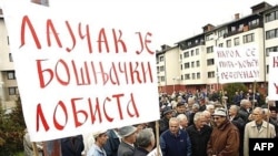 A Bosnian Serb holds a banner reading "Lajcak is a Bosnian Muslim lobbyist" at a protest in Pale in 2007.