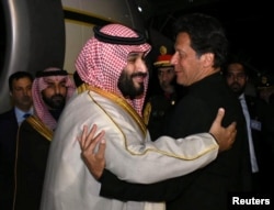 Pakistani Prime Minister Imran Khan (right) greets Saudi Arabia's Crown Prince Mohammed bin Salman on his arrival at Pakistan Air Force (PAF) Nur Khan Base in Rawalpindi on February 17.
