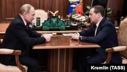 Russian President Vladimir Putin (left) meets with Dmitry Medvedev at the Kremlin in Moscow on January 15.