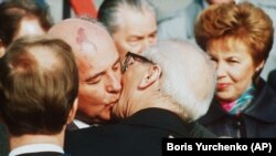 Mihail Gorbaciov îl îmbrățișează pe liderul est-german Erich Honecker la sosirea pe aeroportul Schoenefeld în Berlinul de răsărit pe 6 octombrie 1989. (AP-Photo/Boris Yurchenko)