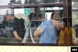 Turkish plainclothes policemen accompany detained soldiers following the failed coup attempt as they arrive at an Istanbul court July 20.