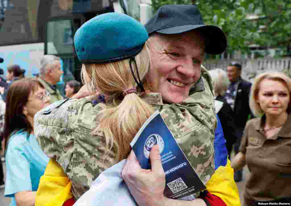 Військовослужбовиця обіймає звільненого українського захисника після обміну полоненими 19 червня 2025 року, чоловік не стримує усмішки