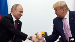 Путін (ліворуч) і Трамп (праворуч) тиснуть руки під час двосторонньої зустрічі на полях саміту G-20 в Осаці, Японія, 28 червня 2019 року