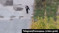 Чоловік несе на руках поранену російськими окупантами, що проникли у місто, жительку Покровська