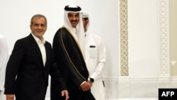 Iran's President Maoud Pezeshkian (left) and Qatar's Emir Sheikh Tamim bin Hamad Al Thani arrive to give a joint press conference in Doha, October 2024