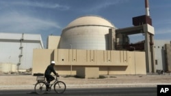A worker rides a bicycle in front of the reactor building of Iran's Bushehr nuclear power plant. (file photo) 