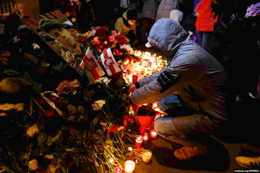 People lay flowers to pay tribute to Raman Bandarenka in a courtyard that has been dubbed the "Square of Changes" in Minsk on November 12.