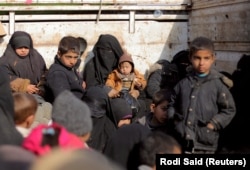 Жени и деца седат во камион во близина на Багуз, последното територијално упориште на ИСИЛ во Сирија, 2019 година.