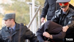 Two suspects being arrested for the mass killings in Kushchevskaya