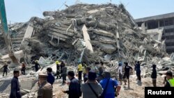 Люди стоять біля місця, де зруйнувалася будівля після сильного землетрусу, Бангкок, Таїланд, 28 березня 2025 року