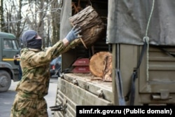 Російські військові у Сімферополі завантажують спиляні дерева в межах акції «Бліндажі в теплі», лютий 2025 року
