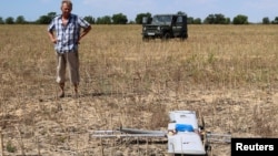 Фермер оглядає російський бойовий безпілотник, який впав на його поле під час нападу Росії на Україну, Херсонська область, Україна, 24 липня 2025 року
