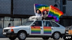 Gay-rights activists hold rainbow flags during a protest in central Moscow in May 2014.