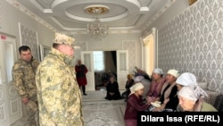 Прибывшие на похороны Мухамедияра Тастана военные стоят напротив членов его семьи. 9 ноября 2025 года