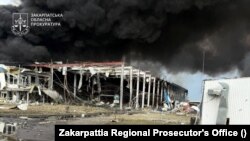 Fumul se ridică deasupra fabricii Flextronics din Mukacevo, regiunea Transcarpatia, lovită de un atac cu rachete rusești pe 21 august 2025.