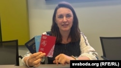 Аляксандра Мамаева, прадстаўніца дэмакратычных сіл Беларусі ў ПАРЭ, прадстаўніца Народнай амбасады Беларусі ў Славеніі, трымае тры свае дакумэнты: пратэрмінаваны беларускі пашпарт, падарожны дакумэнт для замежніка выдадзены ўрадам Славеніі і пашпарт Новай Беларусі