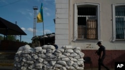 Un membru al Serviciului de Stat pentru Situații de Urgență al Ucrainei intră în subsolul fortificat al gării folosit pentru anchete în timpul ocupației rusești în localitatea recucerită Kozacea Lopan, Ucraina, 18 septembrie 2022