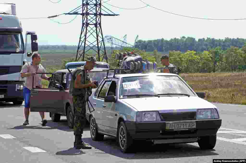  Un militar ucrainean verificând documentele la un punct de control lângă Mariinka, în august 2014. 
