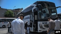 Iranieni urcă în autobuzul care călătorește spre Van, un oraș din estul Turciei, aproape de granița cu Iranul, în terminalul de autobuze Esenler din Istanbul, pe 18 iunie 2025.