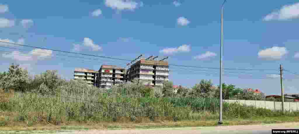 Напротив пляжа стоят недостроенные и заброшенные многоэтажки